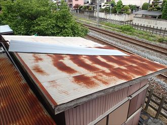 屋根が吹き飛ばされた波板屋根の物置