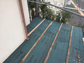 瓦棒の間にガルバリウム鋼板の屋根を嵌め込んでいきます