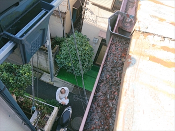 剥がれた塗膜が雨樋に堆積していて詰まっています