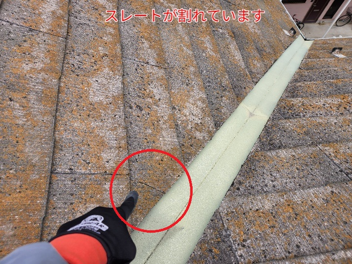 割れたスレートを指差しで示した画像。