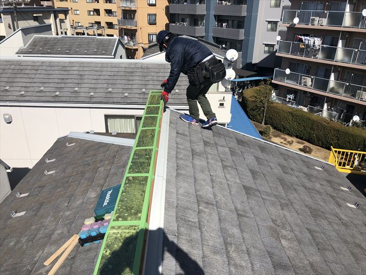 雨漏れ防止の養生を貼っている様子