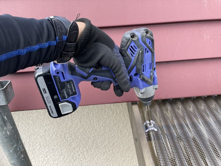 フックを通す穴をあけている様子