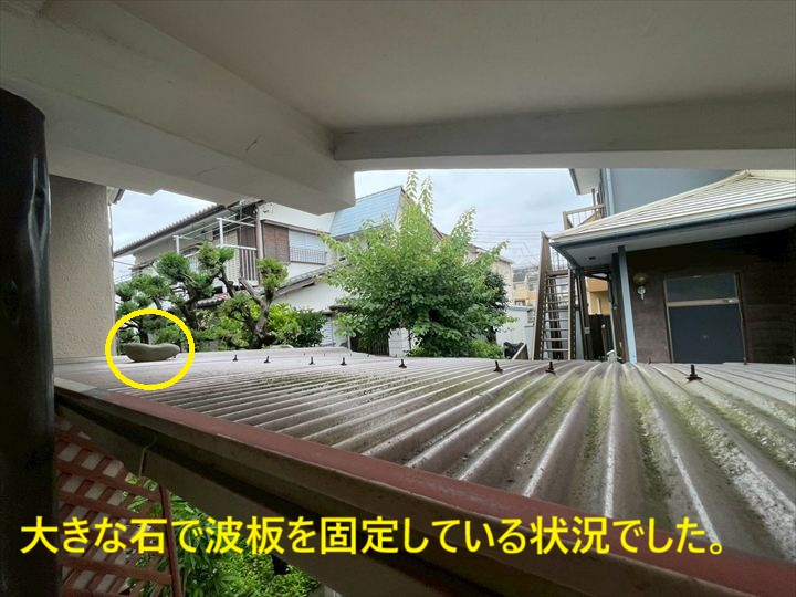 大きな石で波板を固定している状況でした。